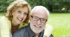 An older couple smiling after discovering the cost of CEREC crowns at Bawa Dentistry