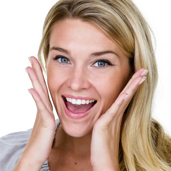 Woman is happily smiling with hands close to her face