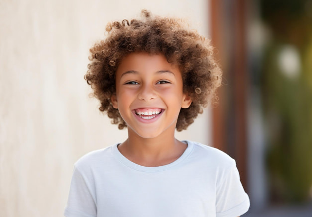 A boy is happily smiling in a park