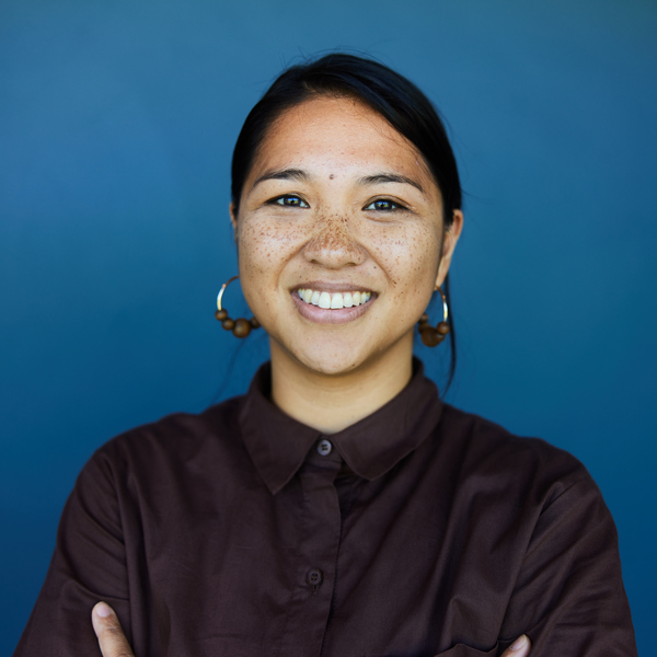 Young business woman smiling in front of a blue background
