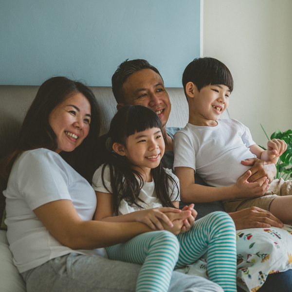 Happy family on the bed and watching TV together