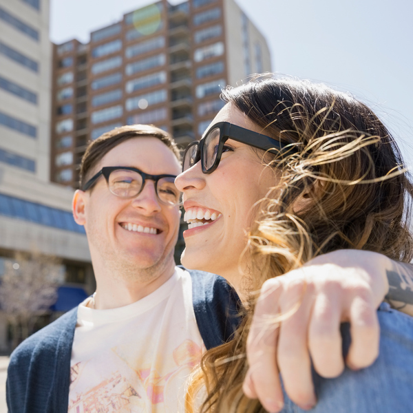 Couple laughing on sunny urban street