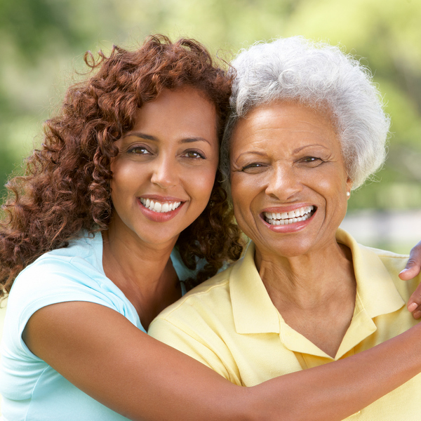 Mother and daughter are hugging and smiling in the park